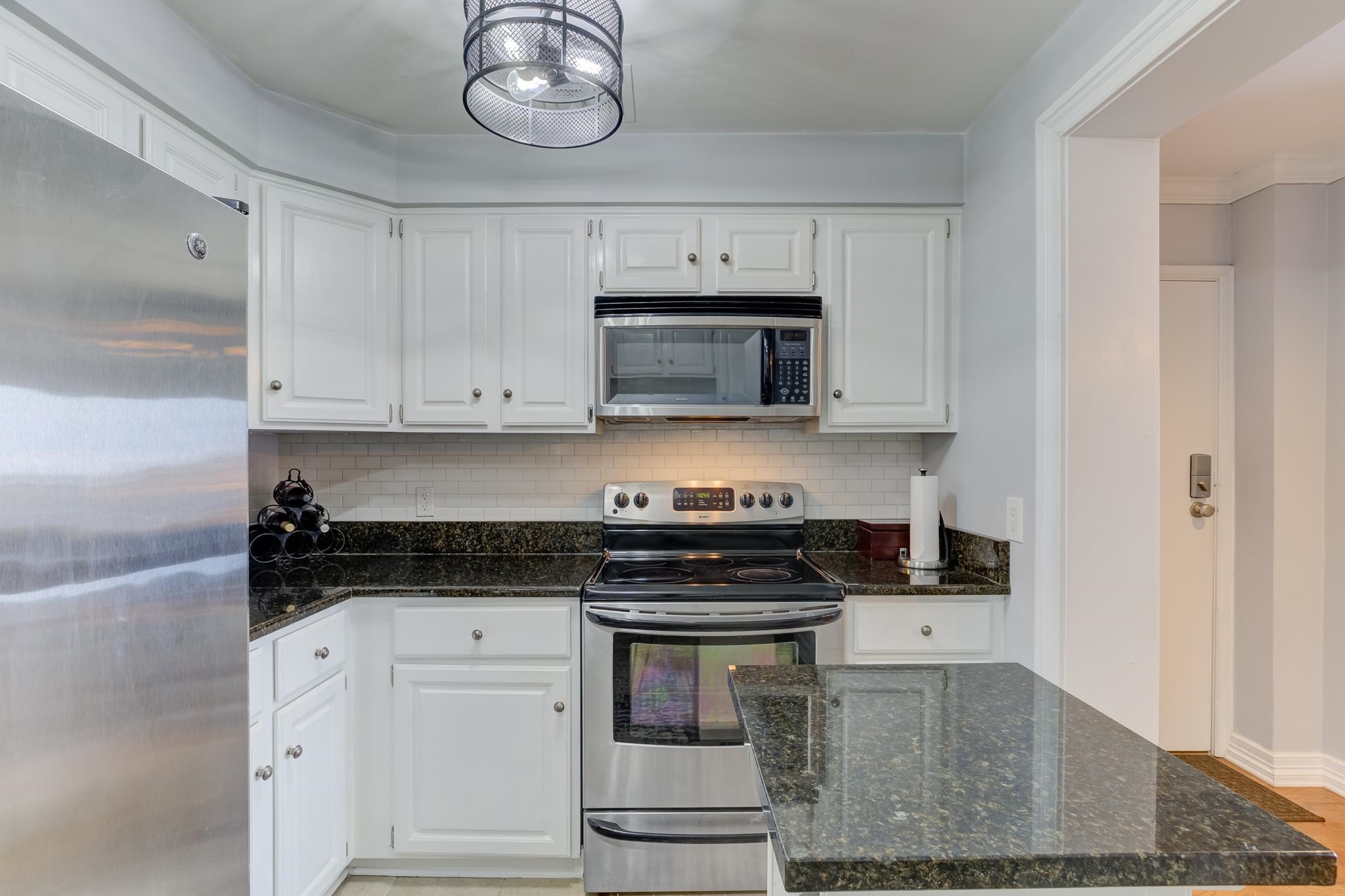 655 Riverside Drive, Unit 506B Memphis, TN 38103 - Photo 5 of 26 a kitchen with white cabinets and stainless steel appliances