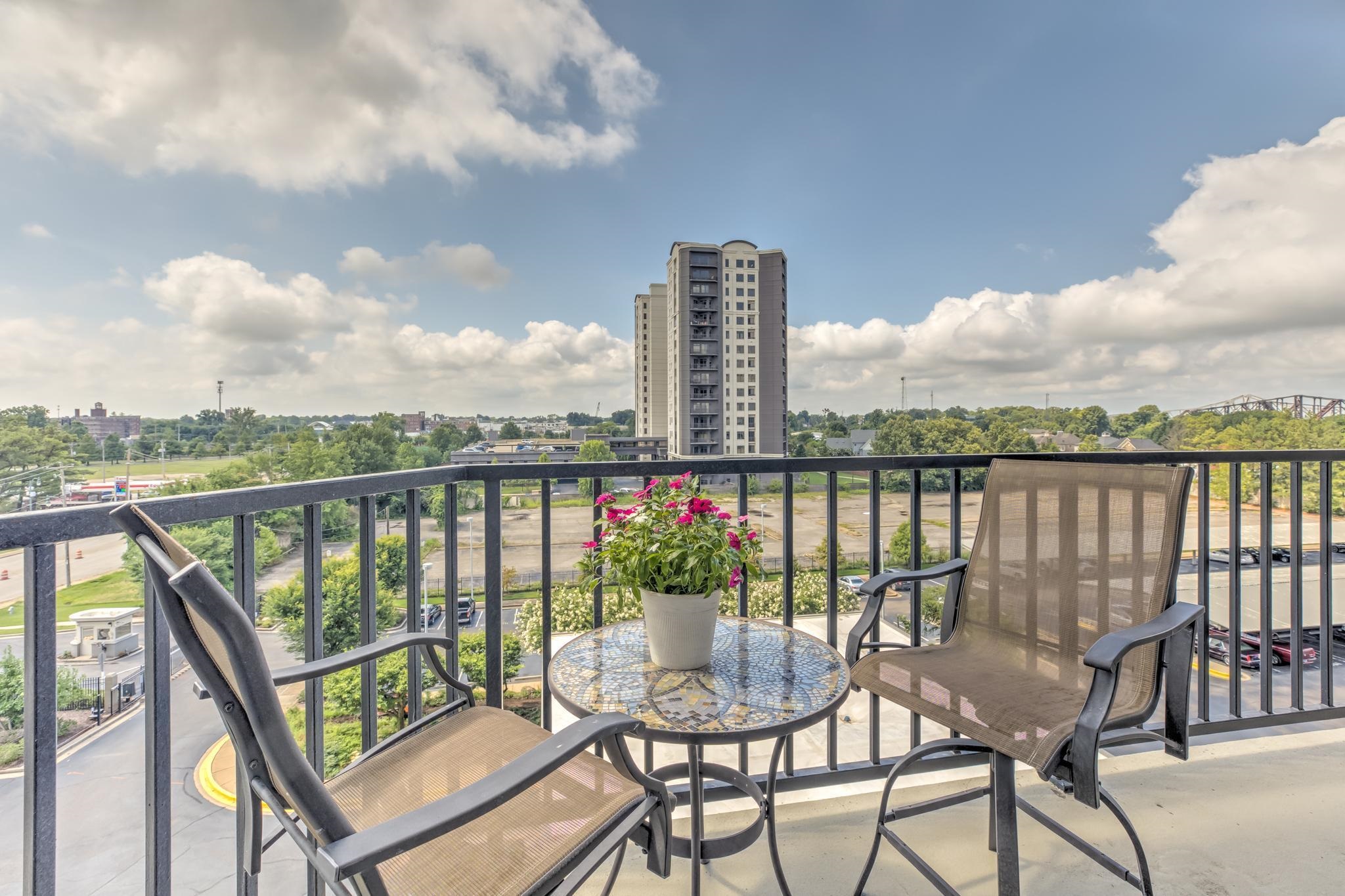 655 Riverside Drive, Unit 506B Memphis, TN 38103 - Photo 9 of 26 a view of a balcony with wooden chairs and wooden floor
