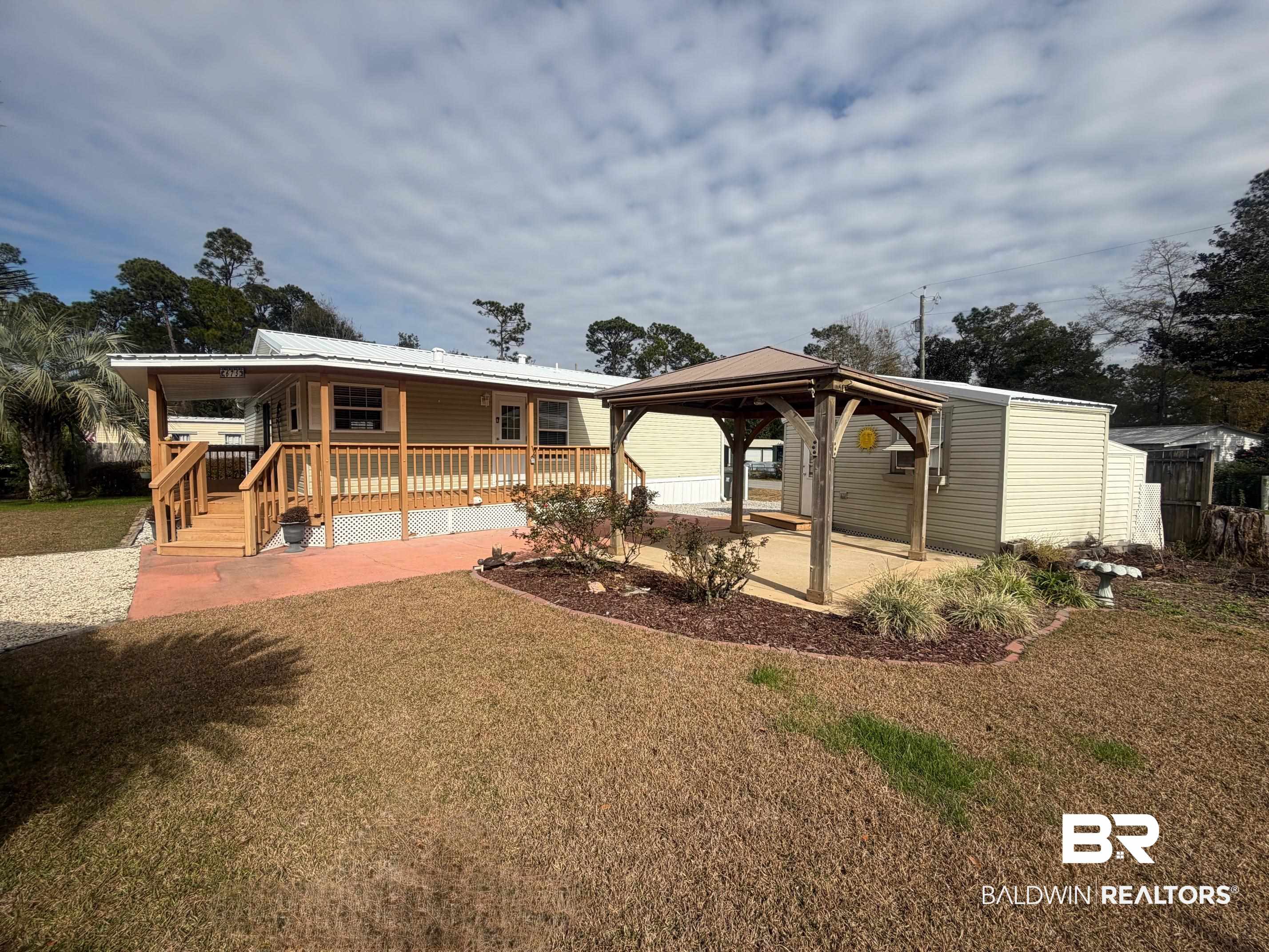675 Escambia Loop Lillian, AL 36549 - Photo 5 of 44 Rear view of property with a yard, a gazebo, a patio, and a metal roof