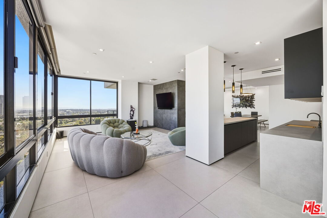 10350 Wilshire Boulevard, Unit 1203 Los Angeles, CA 90024 - Photo 22 of 69 a large living room with a large window and a flat screen tv
