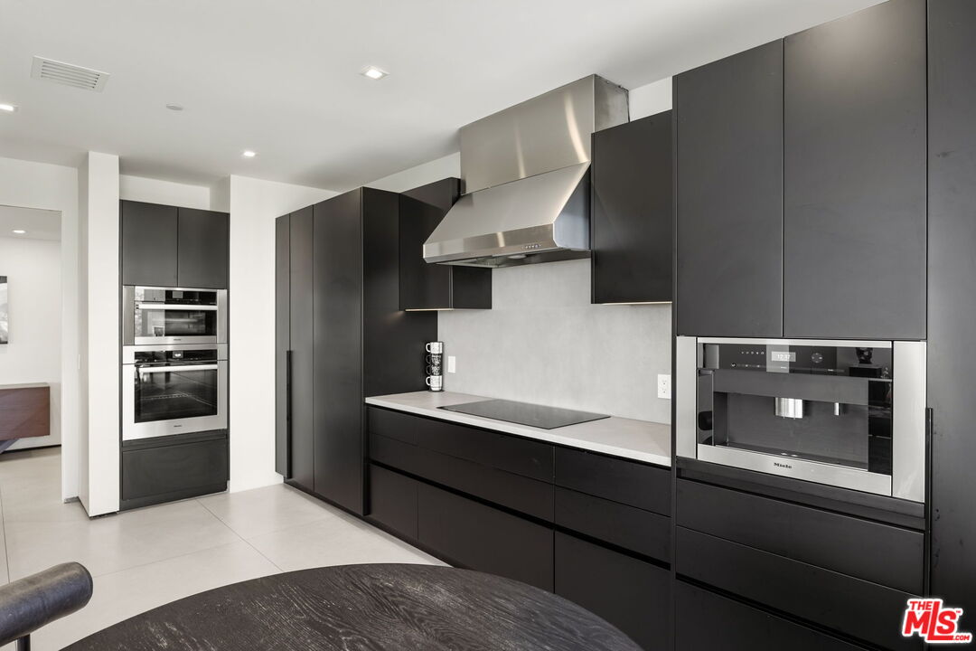 10350 Wilshire Boulevard, Unit 1203 Los Angeles, CA 90024 - Photo 23 of 69 a kitchen with stainless steel appliances kitchen island a refrigerator sink and cabinets