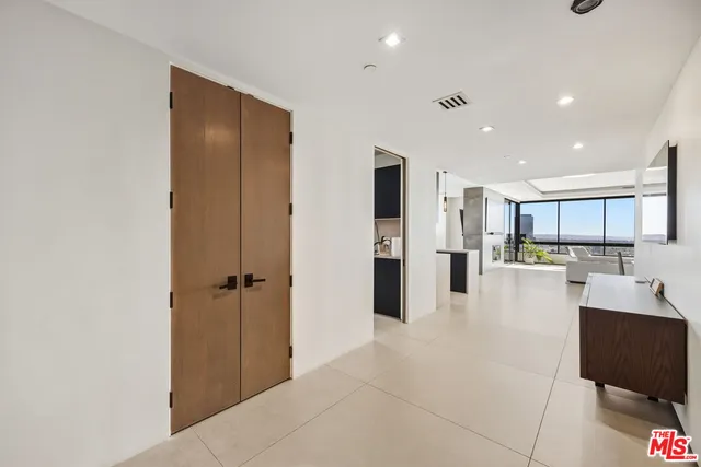 a view of an empty room with closet and a bathroom