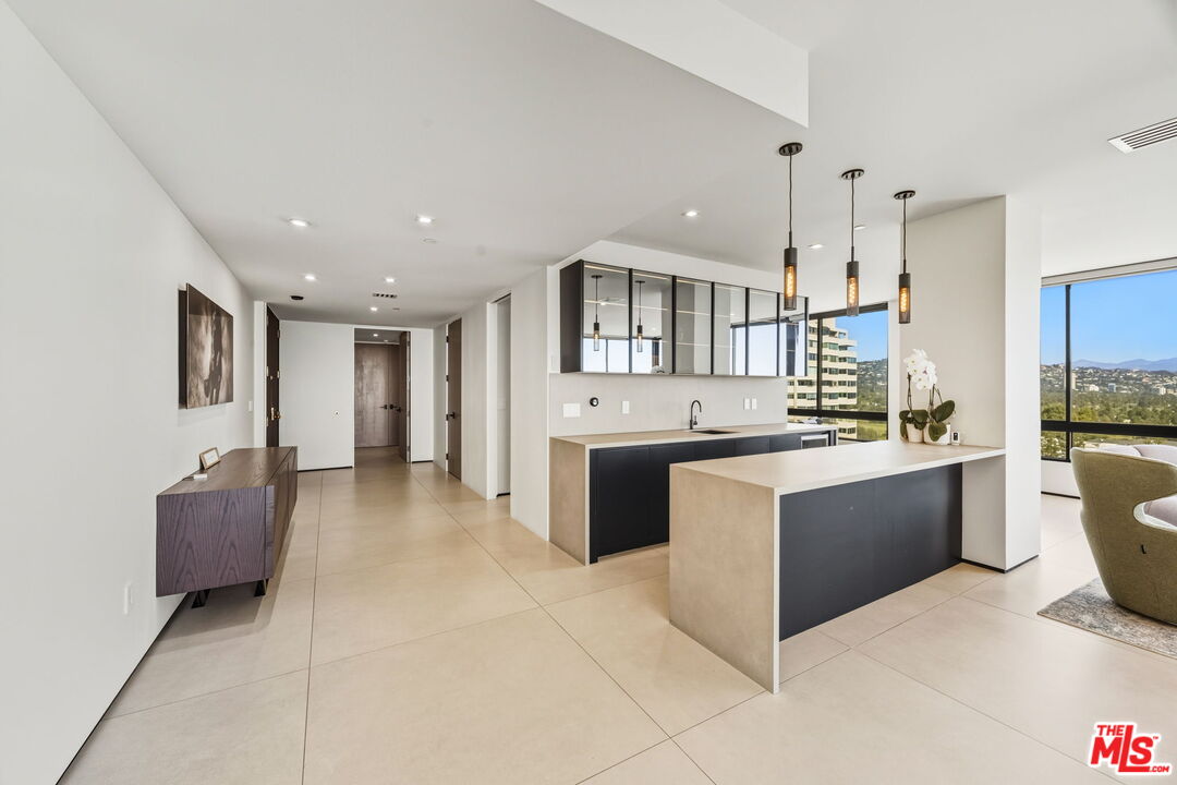 10350 Wilshire Boulevard, Unit 1203 Los Angeles, CA 90024 - Photo 6 of 69 a large kitchen with a large counter top appliances and cabinets