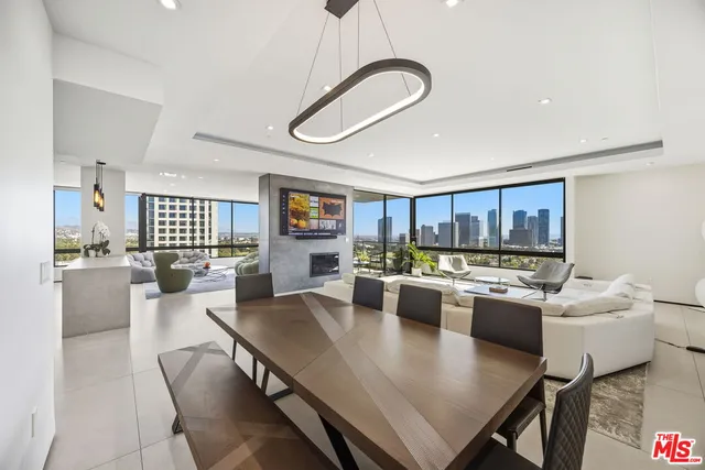 a very nice looking dining room with a large window and kitchen view