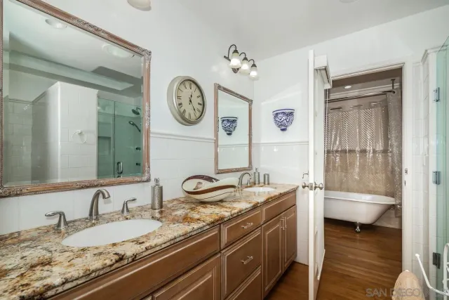 a bathroom with a granite countertop sink mirror vanity and toilet