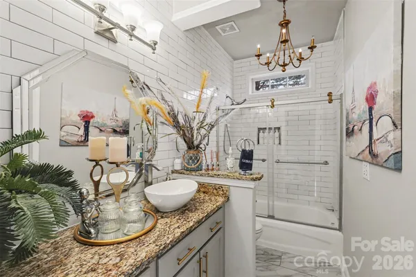 a bathroom with a granite countertop sink a toilet and mirror