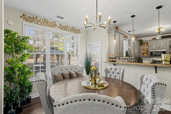 a dining room with furniture a large window and wooden floor