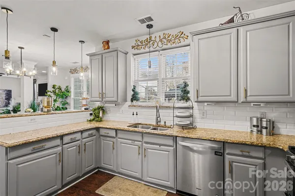 a kitchen with stainless steel appliances granite countertop a sink a counter space and cabinets