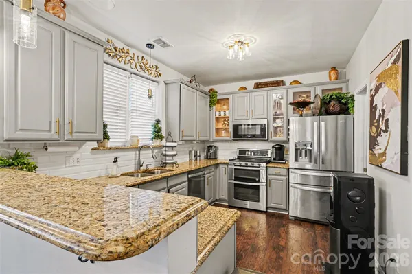 a kitchen with stainless steel appliances granite countertop a sink stove and refrigerator