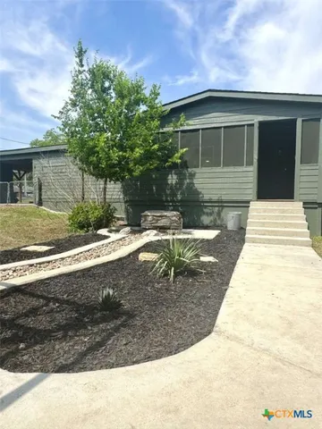 a view of a white house with a yard