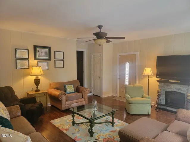 a living room with furniture a fireplace and a flat screen tv