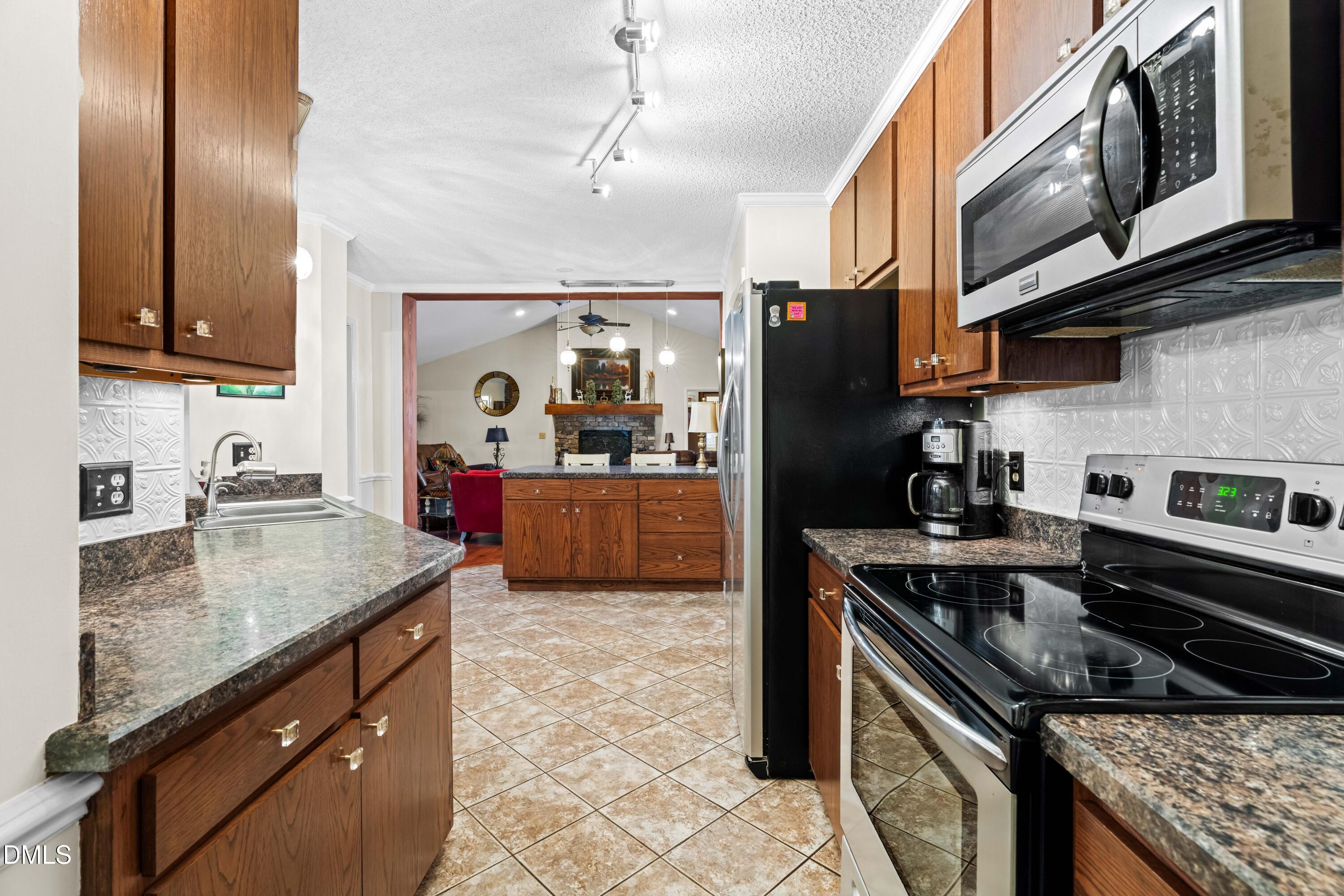 335 Sprunt Drive Clinton, NC 28328 - Photo 24 of 52 a kitchen with stainless steel appliances granite countertop a sink stove and refrigerator