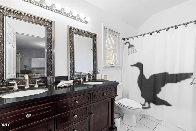 a bathroom with a granite countertop sink mirror vanity and toilet