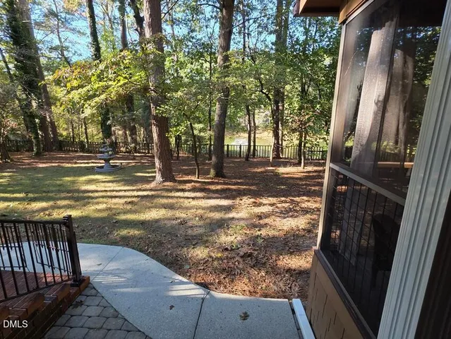 a view of a yard with wooden fence and a bench