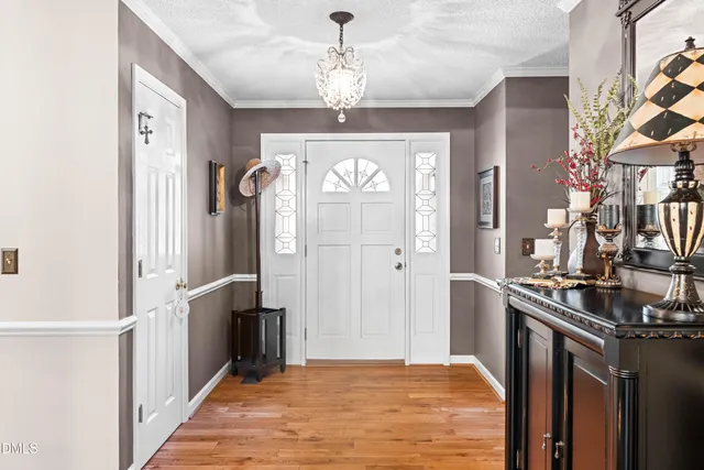 a view of a dining room with furniture a chandelier and wooden floor