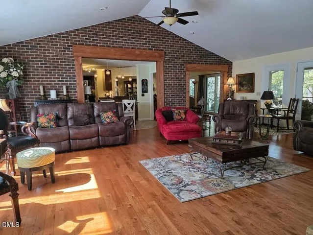 a living room with furniture a rug and a dining table
