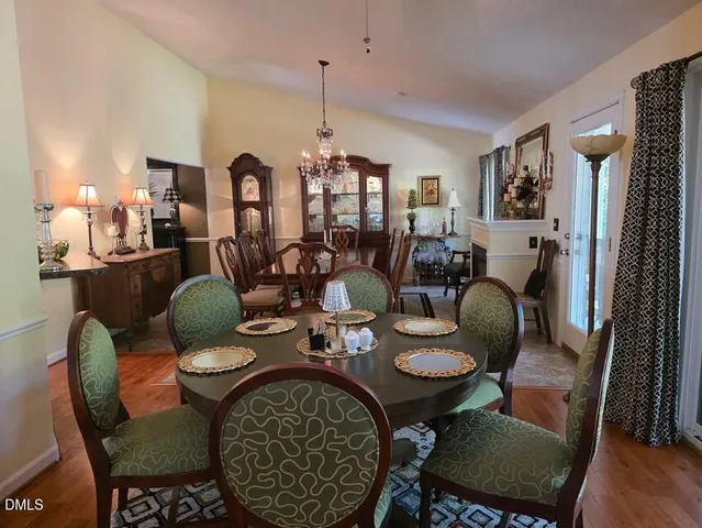 a dining room with furniture a chandelier a glass table and chairs