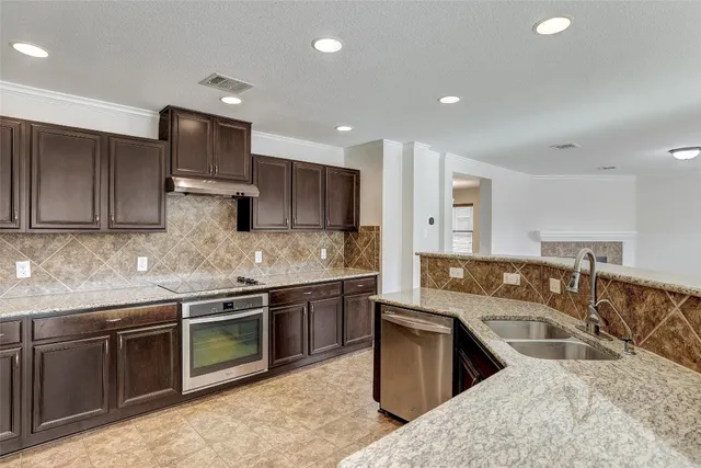 a kitchen with stainless steel appliances granite countertop a sink stove and refrigerator
