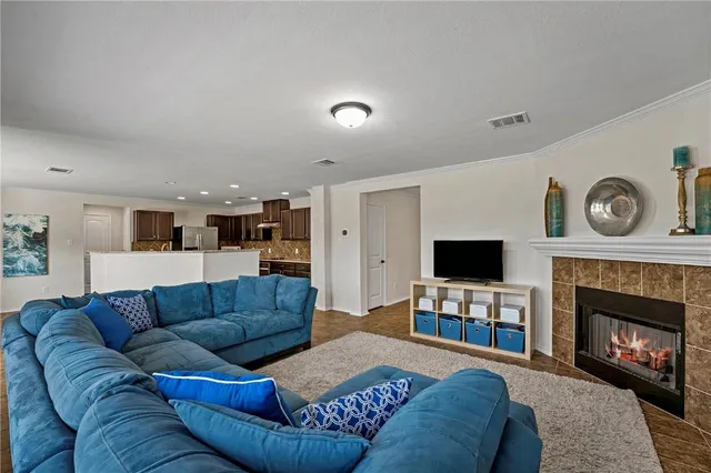 a living room with furniture a fireplace and a flat screen tv