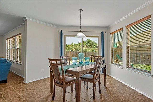 a dining room with furniture large windows and a chandelier