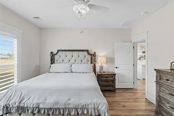 a bedroom with a bed and wooden floor