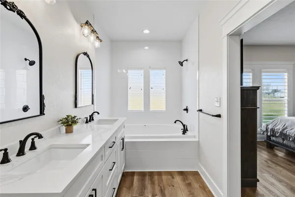 a bathroom with a tub sink and mirror