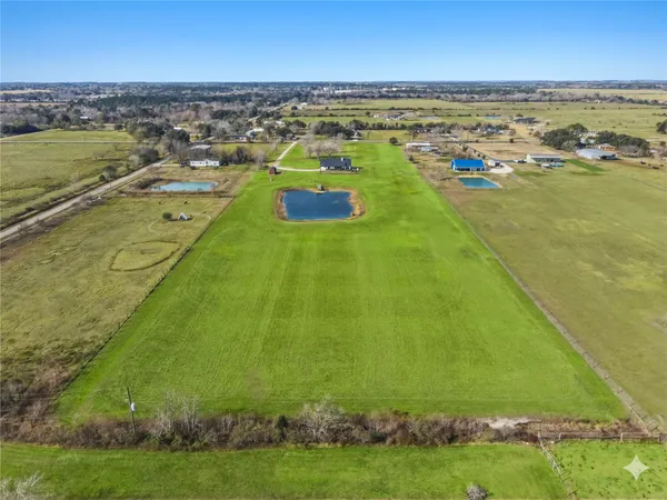 an aerial view of a house with a garden and lake view