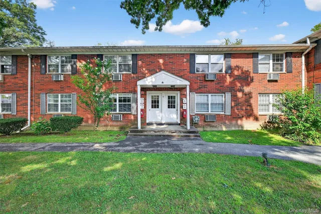 front view of a brick house with a yard