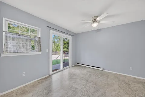 an empty room with windows and fan