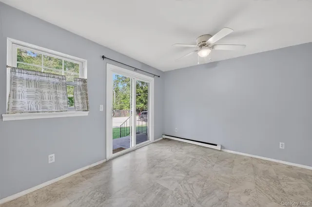 an empty room with windows and fan