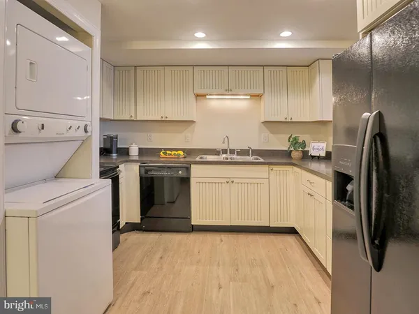a kitchen with granite countertop white cabinets and stainless steel appliances
