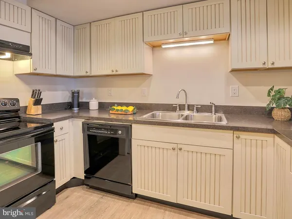 a living room with stainless steel appliances wooden floor and a window