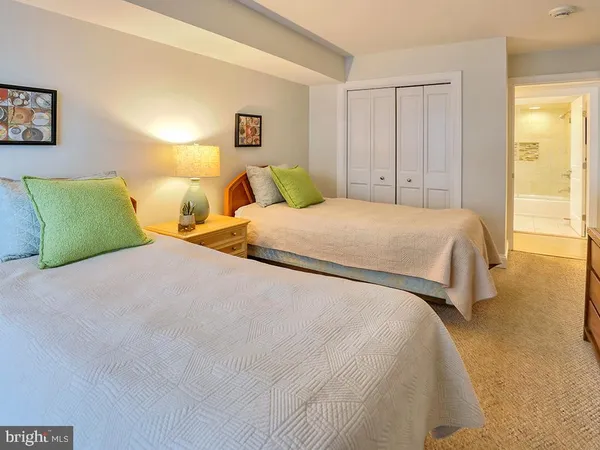 a bedroom with a bed a chandelier and a dresser