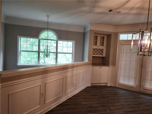 a view of a hallway with wooden floor and chandelier