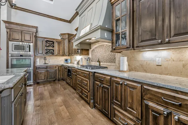 a kitchen with stainless steel appliances granite countertop a sink and wooden cabinets