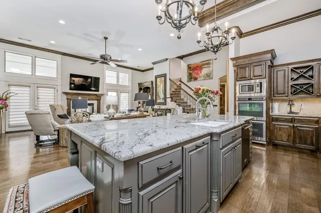 a kitchen with stainless steel appliances granite countertop a stove and a wooden cabinets