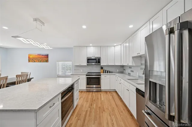 a kitchen with stainless steel appliances a refrigerator sink and cabinets