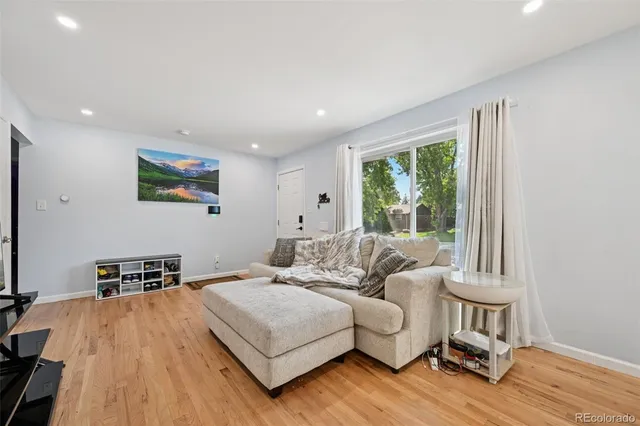 a living room with furniture and a wooden floor
