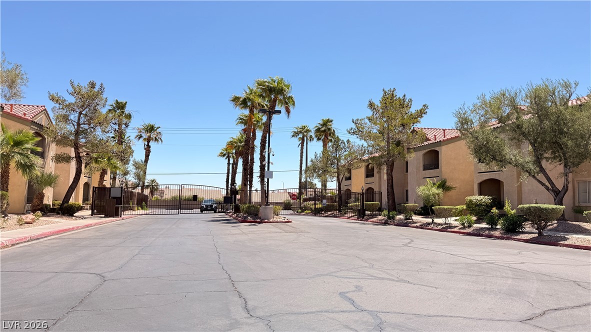 7885 West Flamingo Road, Unit 1131 Las Vegas, NV 89147 - Photo 4 of 36 A secured community entry welcomes residents, framed by lush palm trees and mature landscaping.