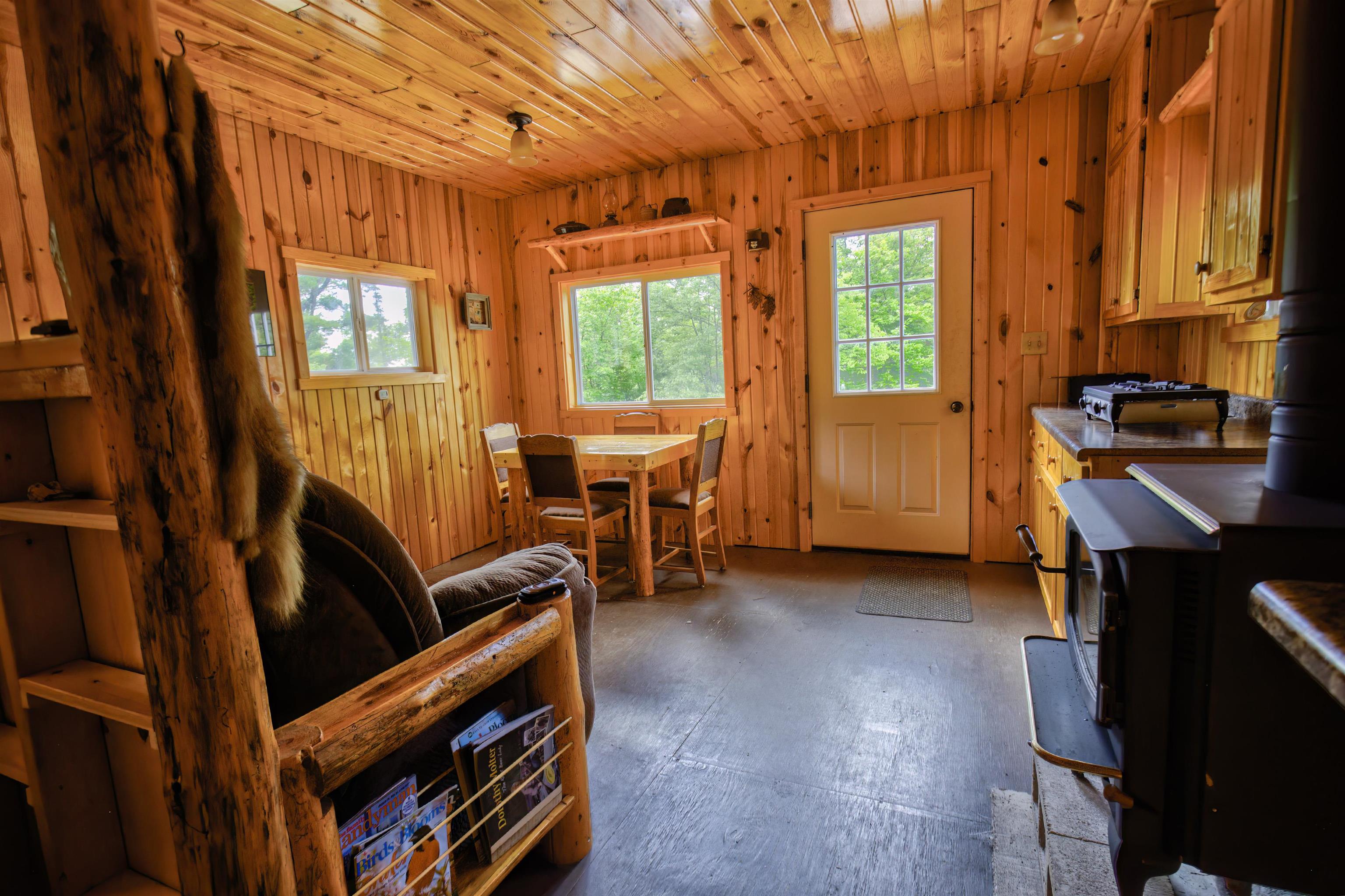 4194 Nels Lake Road Ely, MN 55731 - Photo 13 of 27 Dining space with wood walls, concrete floors, and wooden ceiling
