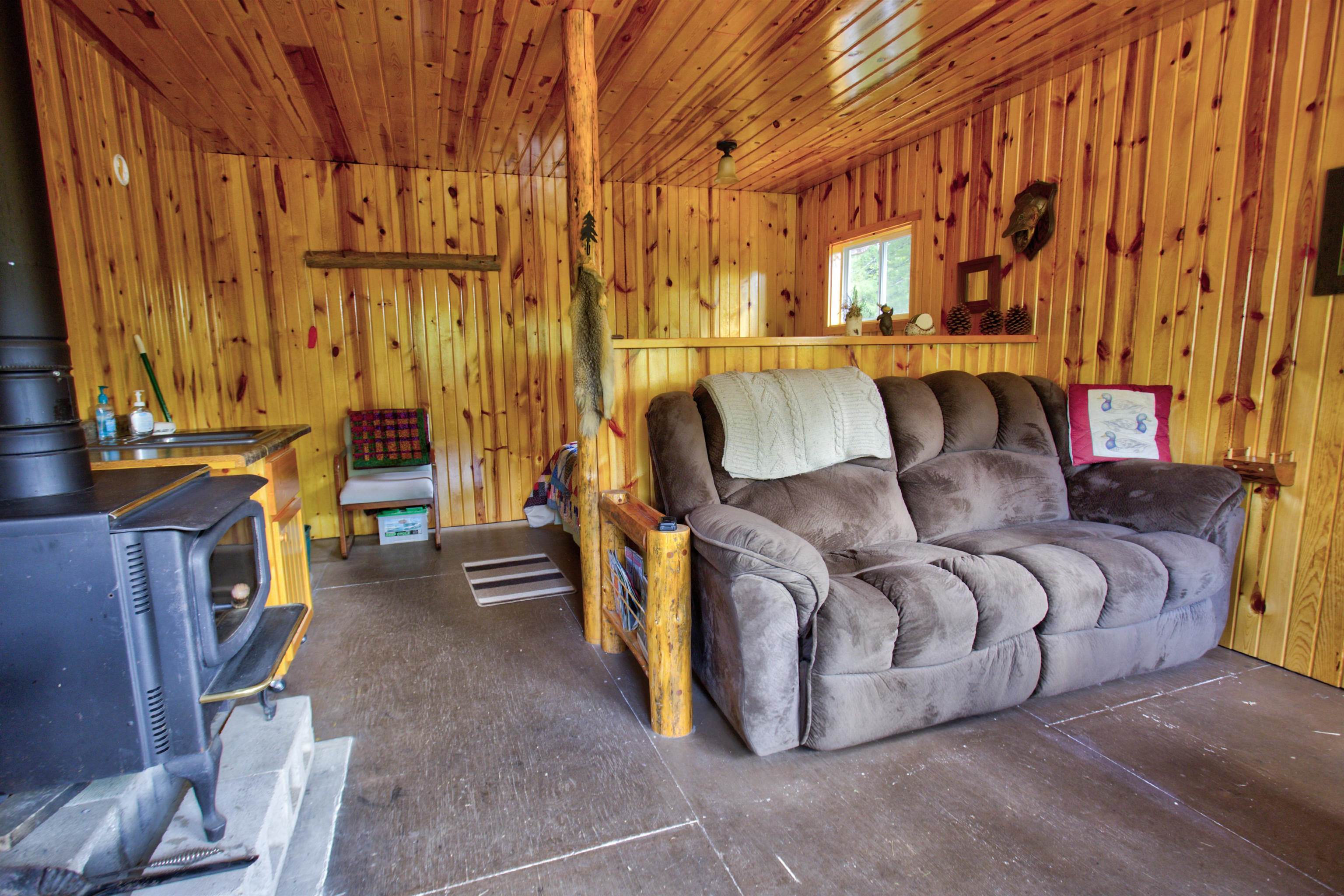 4194 Nels Lake Road Ely, MN 55731 - Photo 14 of 27 Living room featuring a wood stove, wood walls, and wood ceiling