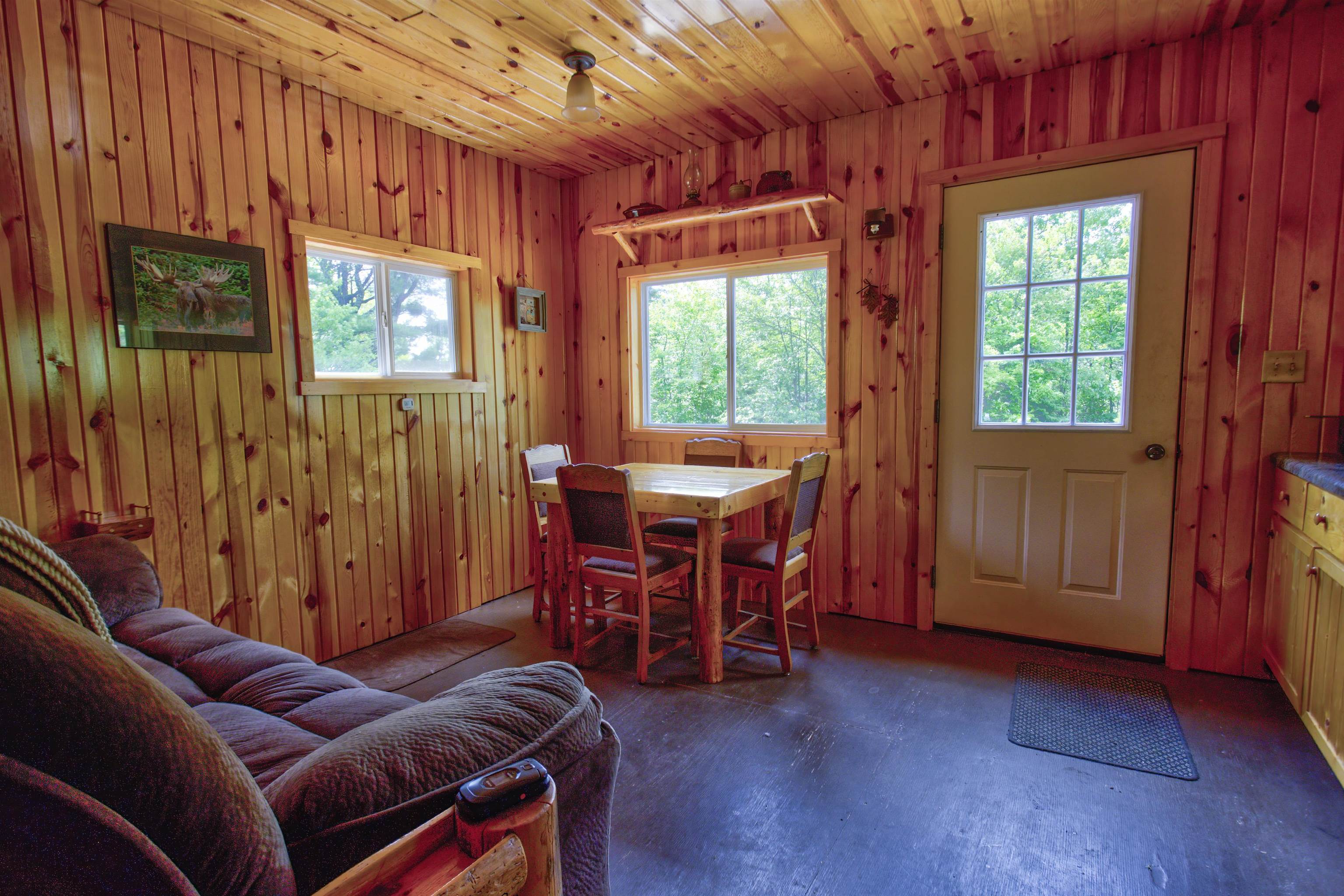 4194 Nels Lake Road Ely, MN 55731 - Photo 9 of 27 Dining space featuring healthy amount of natural light, wood walls, and concrete flooring