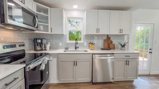 a kitchen with stainless steel appliances granite countertop a stove and a sink