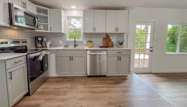 a kitchen with stainless steel appliances granite countertop a stove a sink dishwasher and a refrigerator