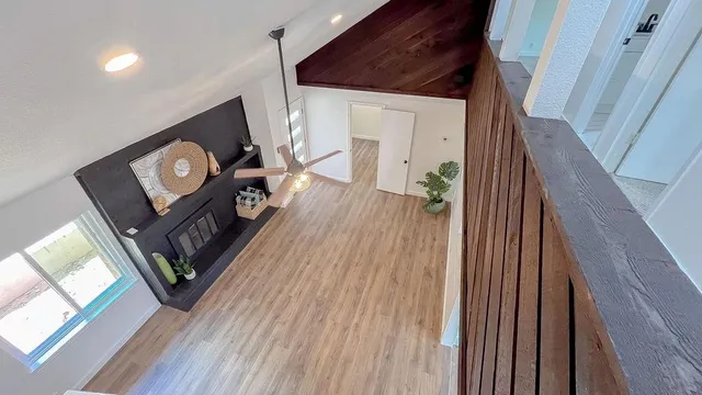a view of a hallway with wooden floor and stairs