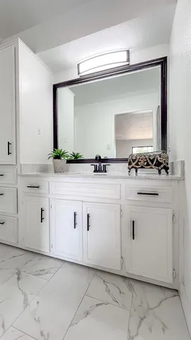 a view of white cabinets with sink and dishwasher