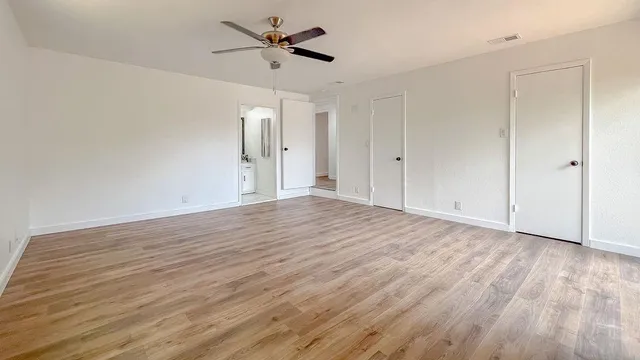 a view of empty room with wooden floor