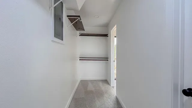 a view of walk in closet with empty racks