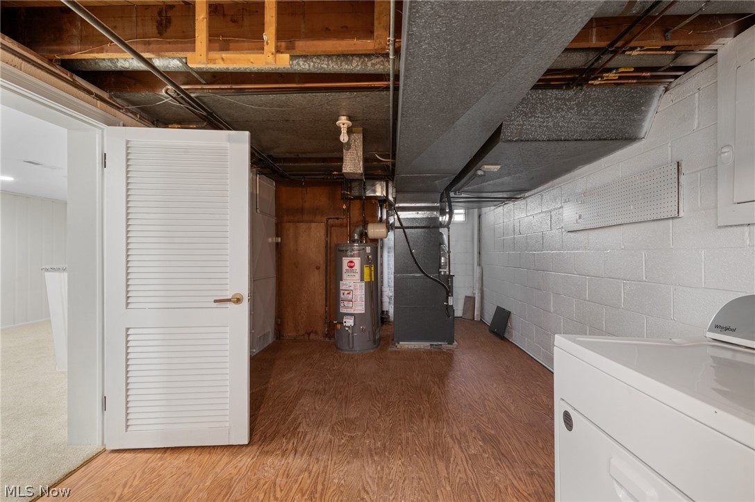 22625 Rye Road Shaker Heights, OH 44122 - Photo 34 of 38 Utility space featuring wood-finish flooring, exposed ceiling joists, and a hot water heater