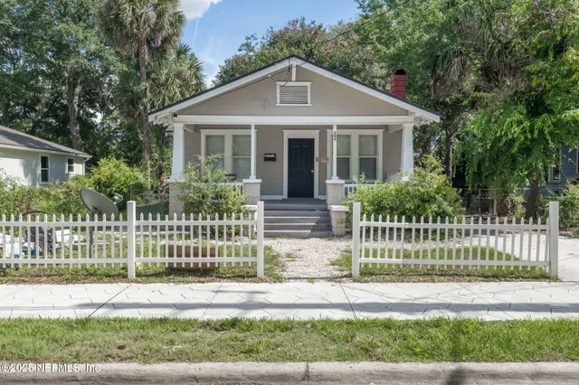 a front view of a house with a garden and plants